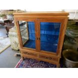 A Chinese display cabinet with carved decoration of prunus flowers, fitted two glass doors and