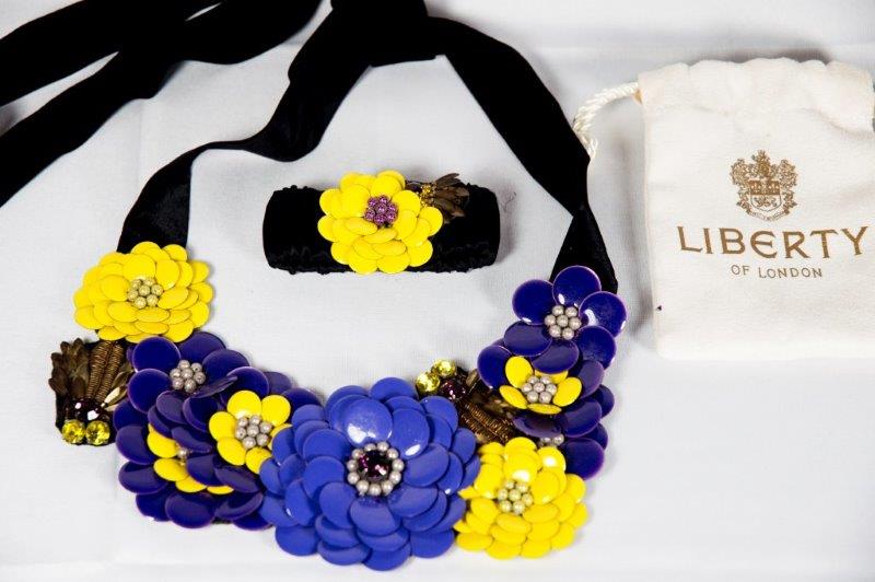 A Liberty black velvet belt decorated to the front in yellow and purple enamel with flowers,