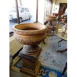 A pair of terracotta garden urns with leaf and bead decoration, complete with leaf clad columns,