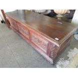 An Italian carved walnut box with hinged lid, leaf and scroll carved panelled front, on scroll feet