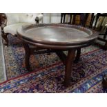 A circular Chinese occasional table with tray top, on four legs united by pierced stretchers