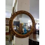 An antique style convex wall mirror and two Edwardian mahogany and inlaid nesting tables