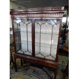 An Edwardian mahogany display cabinet with fret carved cornice, fitted two glass doors and sides