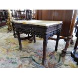 A Chinese occasional table with rectangular marble top, the frieze carved to fruit and flowers, on