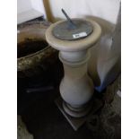 A sundial on a stone baluster form column and circular base