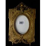 A gilded photograph frame with flower swag decoration to the top, outset corners and swag