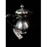 A Continental silver lidded jug with ebonised handle and panelled baluster form body, on circular