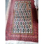 An Eastern rug, deep blue field with repeating floral pattern lozenge centre and border, red