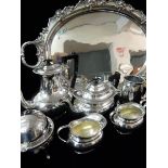 An oval silver plate on copper tray with hop and vine leaf decoration, a four piece plated tea and
