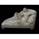 A reconstituted marble study of a female nude on a couch
