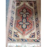 An Eastern rug, red and cream field with stylised decoration in red, blue and cream, red scroll