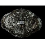 An oval silver dressing table tray with repousse decoration of birds, leaf scrolls and flowers,