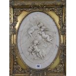 A composition marble design oval plaque with raised decoration of cupids, in an ornate gilt frame