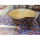 A walnut occasional table with kidney shaped top, on cabriole legs with leaf carved knees