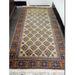 An Eastern rug, gold field with repeating floral pattern and stylised medallion to the centre,