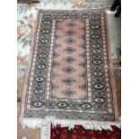 A Bokhara rug, pink with repeating medallion centre - 38in. x 26in. approx.