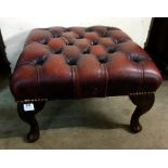 A mahogany and red leather footstool