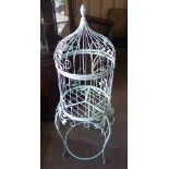 A large painted wire bird cage on stand