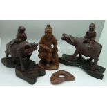 Two carved figures of children on water buffalo with stands and a carved figure of a Chinese elder