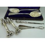 A cased set of silver plated berry spoons, a pair of plated knife rests with mother of pearl