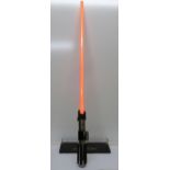 A Hasbro 2007 Star Wars light sabre and stand, in working order, overall length 110cm