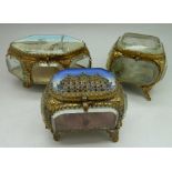 Three gilt metal and glass sided jewellery caskets, one decorated with a view of Boulogne, one with