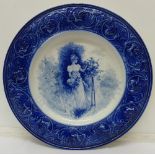 A blue and white charger with transfer print of a maiden,