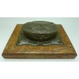 A piece of trench art mounted as a table snuff box on a wooden base