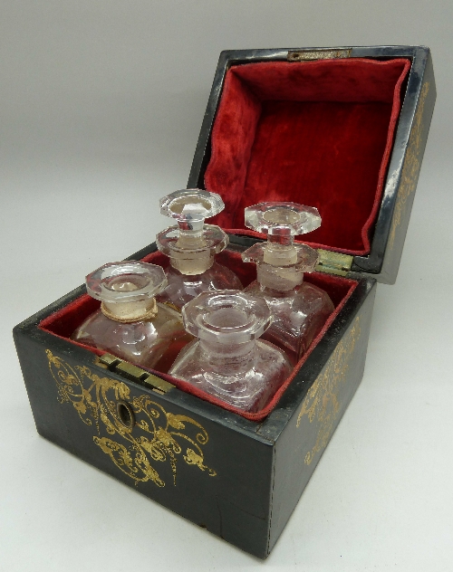 A 19th Century lacquered box with mother of pearl inlay fitted with four scent bottles,