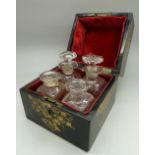 A 19th Century lacquered box with mother of pearl inlay fitted with four scent bottles,