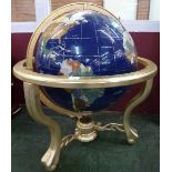 A large gemstone globe with brass base