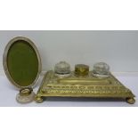 A cast brass desk stand, inkwells a/f and an oval silver photograph frame,