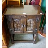 A carved oak two door cupboard