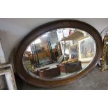 An oval oak framed mirror