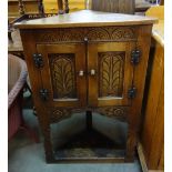 A carved oak corner cupboard