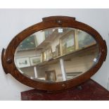 An oval oak framed mirror