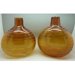 A pair of amber coloured glass vases,