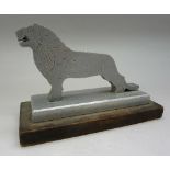 An aluminium model of a lion on a plinth,