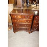 A reproduction mahogany chest of three long and two short drawers