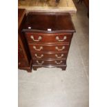 A reproduction serpentine mahogany chest of four drawers