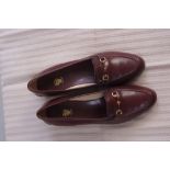A Pair of Gucci shoes.  Brown leather wi
