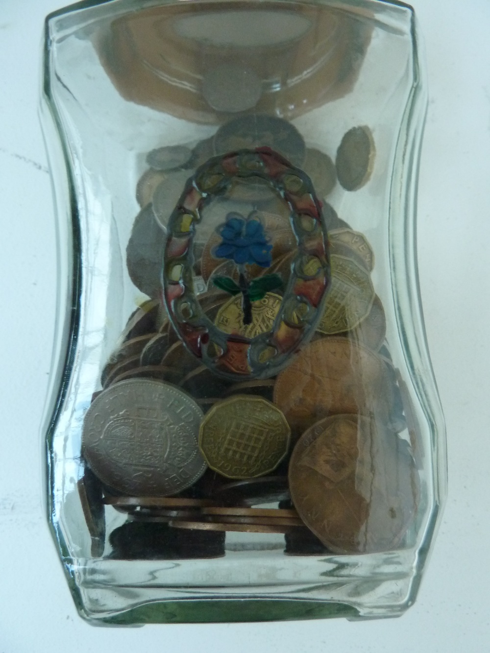 A jar of various coins, including a bras