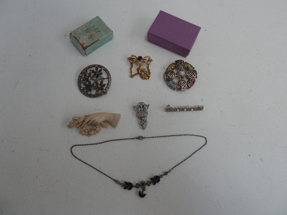 A selection of jewellery including, a Celtic circular brooch, a circular wreath brooch with four