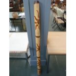 A Didgeridoo decorated with snake and su