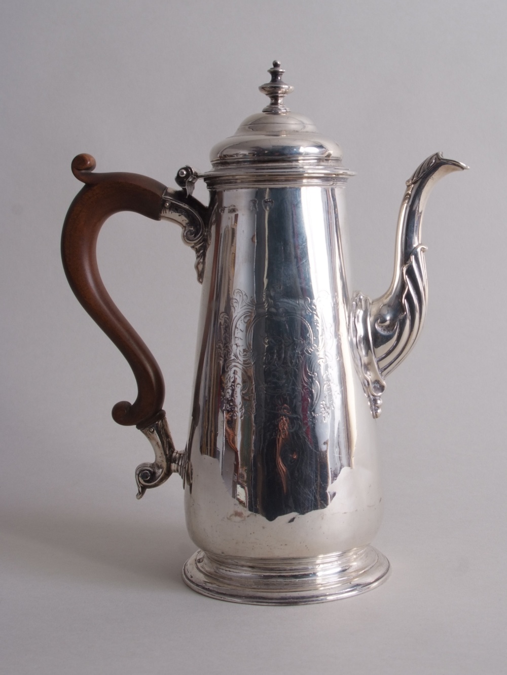 A George II silver coffee pot, London 1744, tapering circular form, foliate-scroll engraving,