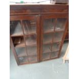 An early 20th century mahogany glazed bookcase, eight glass panel doors (one missing),