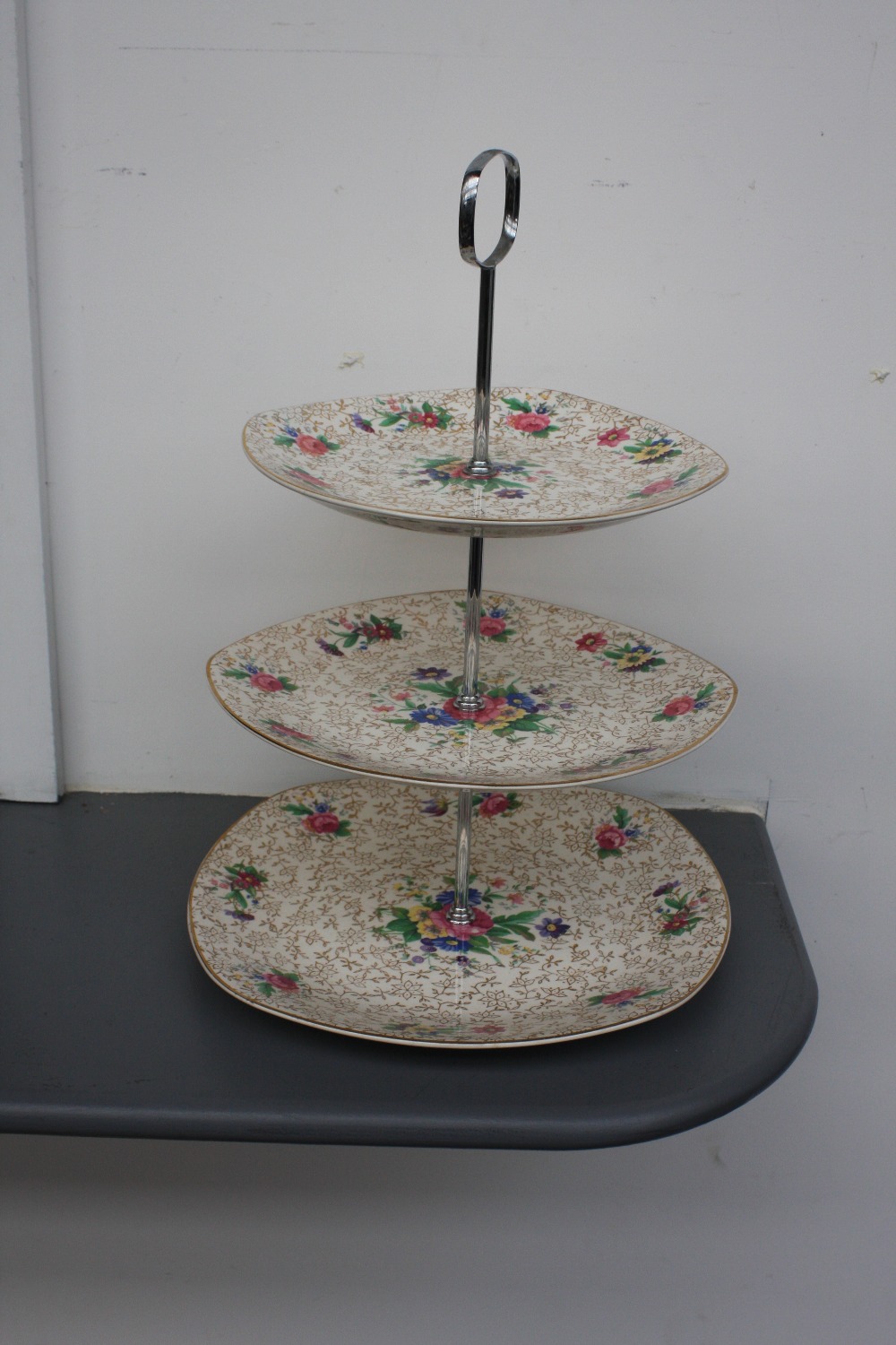 A Midwinter Stylecraft Staffordshire three tier cake stand of floral and gilt design,