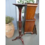 A George III style mahogany torchere, the stepped circular top over octagonal baluster body,