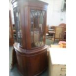 A 20th century mahogany corner cabinet, glazed door over cupboard, on bracket feet,