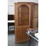 A 20th century pine corner unit, arched top ver two shelves, above two cupboards,